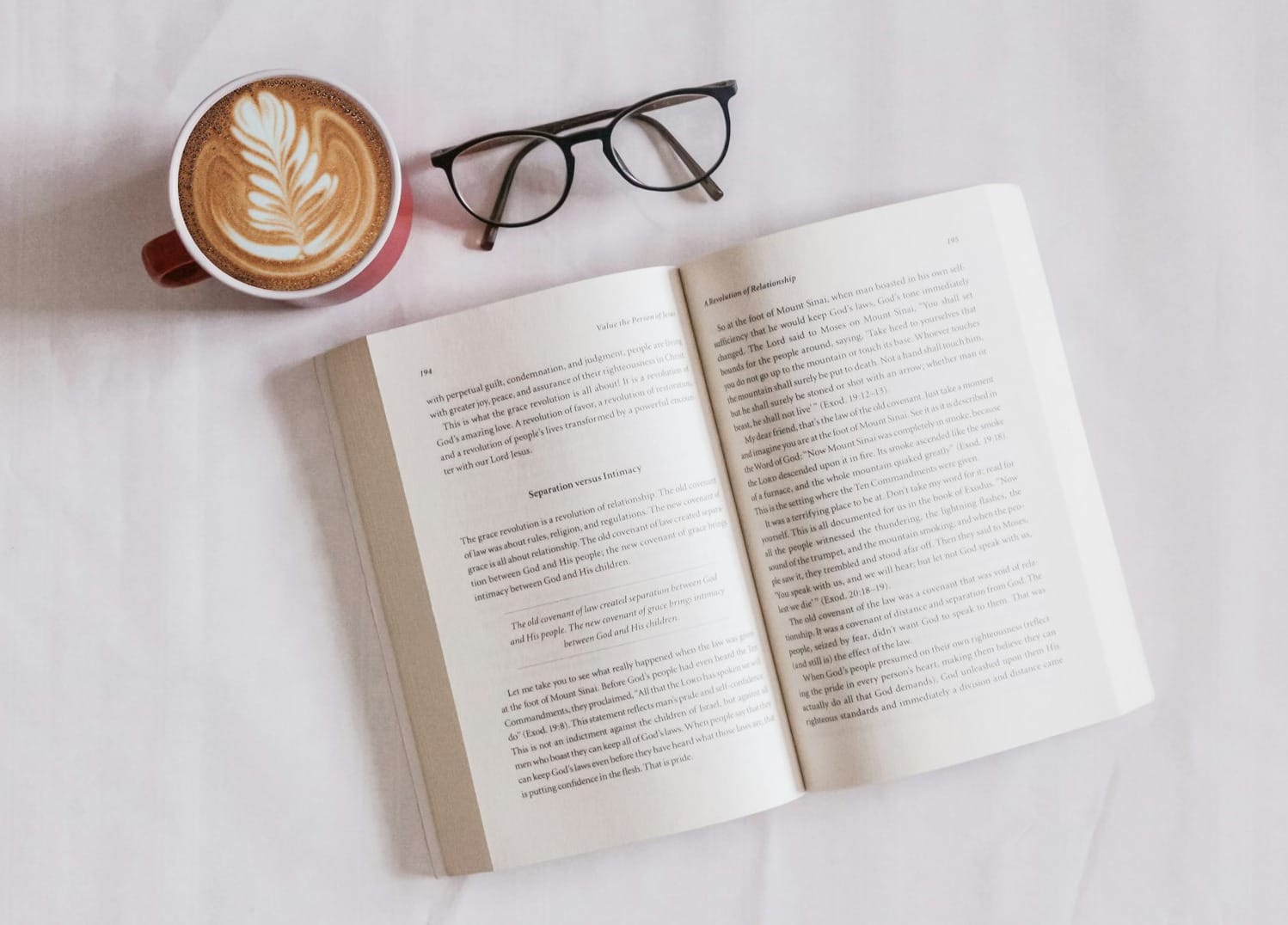 book near eyeglasses and cappuccino